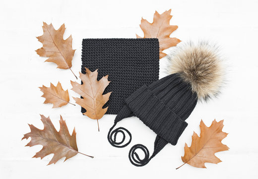 Autumn composition. Knitted hat and snod, autumn leaves. The view from the top.