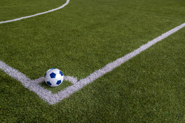 football in corner of artificial grass field