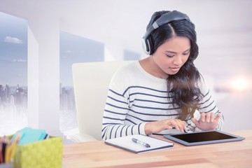 Composite image of smiling asian woman with headphones using