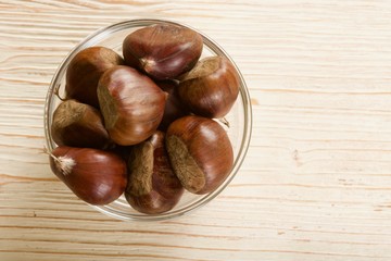 Obraz premium chestnuts on a wooden background