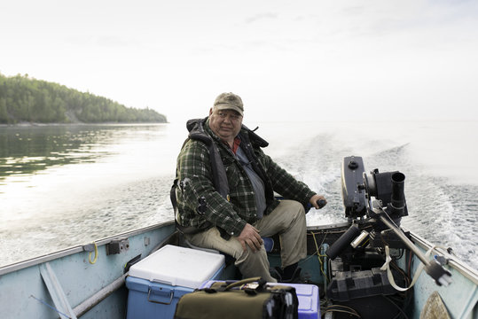 Overweight Middleage Man Fishing In Boat With Downrigger on Georgian Bay