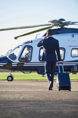 Businessman Walking Towards Helicopter Whilst Talking On Mobile Phone © highwaystarz