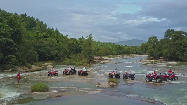Tourists Travel on Quadricycles across Tropical River Rapids