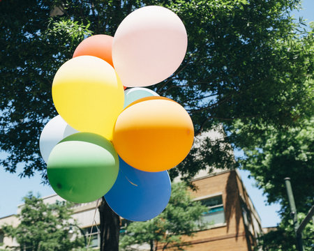 Soft, primary colored balloons in a shopping district during the spring
