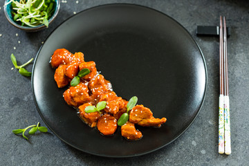 Chinese Food, Fried Chicken with Sesame Seeds in Sweet Source on Black Background