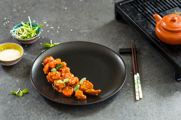Chinese Food, Fried Chicken with Sesame Seeds in Sweet Source on Black Background, Horizontal View