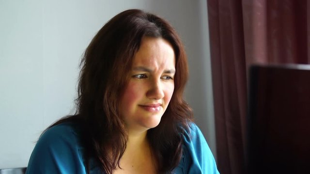 beautiful young emotional woman in front of computer watching to monitor with disgusted face