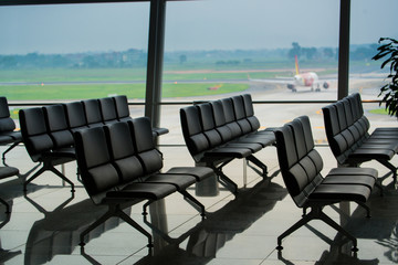 passenger seat in Departure lounge for see Airplane, view from airport terminal.