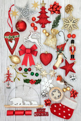 Fototapeta na wymiar Christmas decorative symbols with new and old fashioned bauble decorations, holly, mistletoe, fir and mince pie on rustic white wood background.