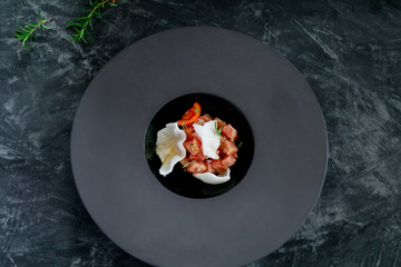 Tuna salad with chips in a black plate. View from above