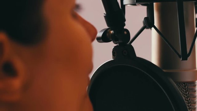 Beautiful girl gives an interview in studio microphone