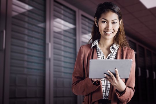 Composite image of smiling businesswoman using a tablet