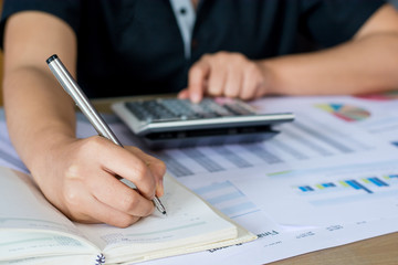 woman hand using calculator and writing make note with calculate