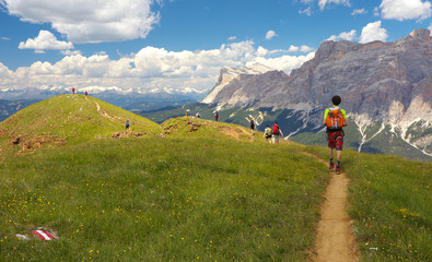 Fototapeta premium Group of walking tourists in the mountains, Dolomites, Italy