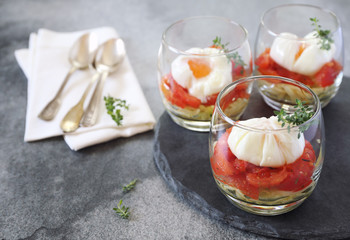 Three verrines breakfast. Poached eggs, tomatoes and zucchini. Citron thyme garnish