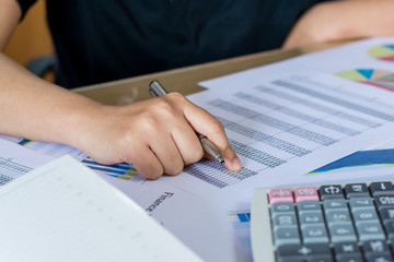 woman hand using calculator and writing make note with calculate,business concept

