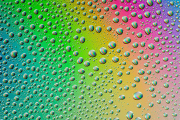 misted glass, drops closeup on rainbow colored background