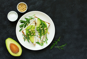 Sandwich with avocado, goat cheese and arugula. View from above.