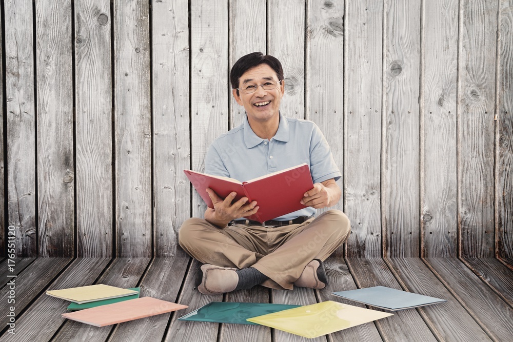 Sticker Composite image of smiling man reading books