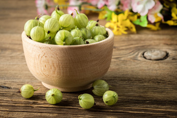 Fresh gooseberry in a wooden bowl.