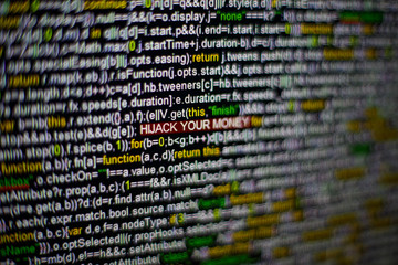 Macro photo of computer screen with program source code and highlighted HIJACK YOUR MONEY...