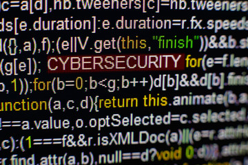 Macro photo of computer screen with program source code and highlighted CYBERSECURITY inscription in the middle. Script on the screen with virus in it. Cyber security concept. Technology background.