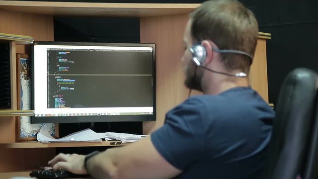 Male programmer working with code on screen