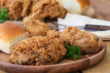 Closeup of Crispy Fried Chicken and Dinner Roll on a Plate