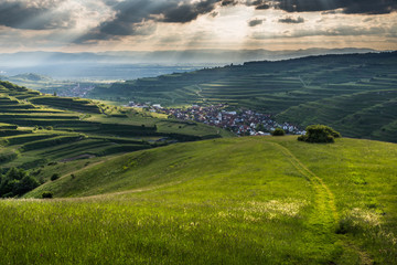 Path leading over hills to small village