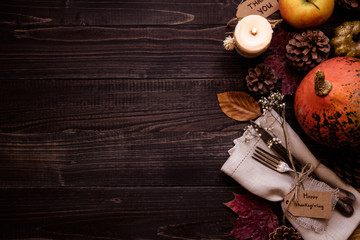 Thanksgiving decoration with cutlery and napkin on the wooden table, top view. Copy space