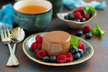 Delicious home-made chocolate dessert Panna cotta. Cream-caramel, caramel custard, with raspberries and blueberries.