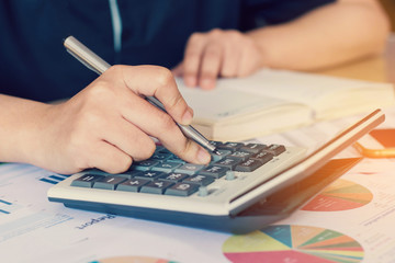 woman hand using calculator and writing make note with calculate