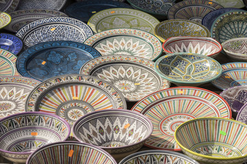 Decorative, hand-painted dishes of a multitude of colors in a traditional art market