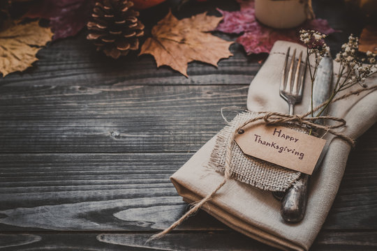 Thanksgiving decoration with cutlery and napkin on the wooden table with copy space