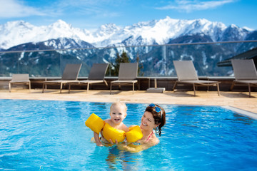 Family in outdoor swimming pool of alpine spa resort