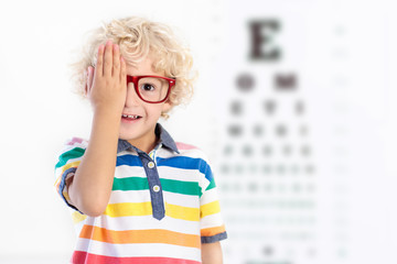 Child at eye sight test. Kid at optitian. Eyewear for kids.