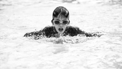 A young boy swimmer doing the butterfly stroke in the swimming pool