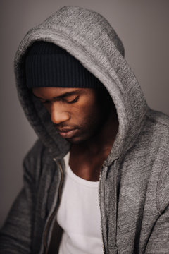 Close up shot of young man in hooded shirt looking down