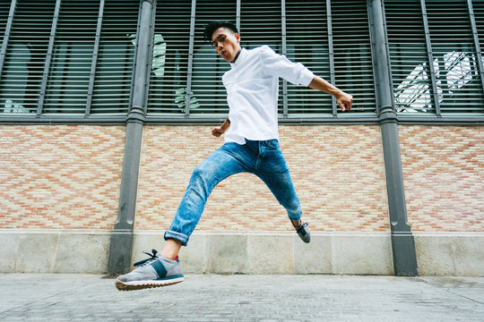 Young asian man jumping on the street.