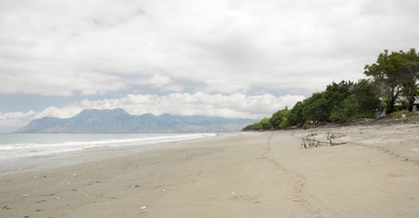 Empty white sand beach with pebbles and clear blue ocean waves at Bajawa Ruting Flores in the morning.