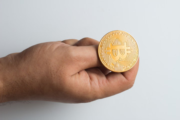 close-up of a hand throwing a golden bitcoin currency