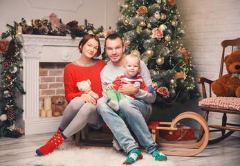 Obraz na płótnie Canvas Happy family among Christmas decorations at home