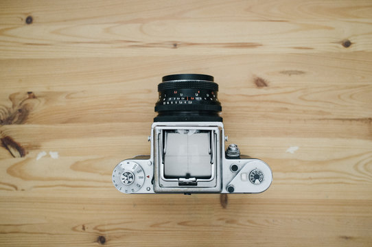 Old camera with opened viewfinder on wooden table