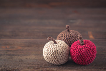 Knitted, crocheted apples on wooden background