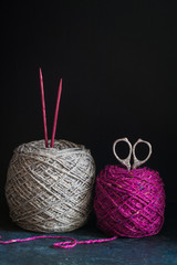 Fuchsia and grey tweed yarn on the dark wooden background