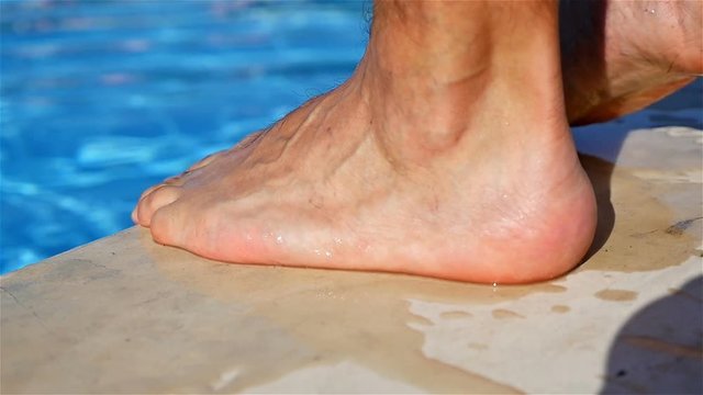 Close up of swimmer feet at the edge of a pool, slow motion