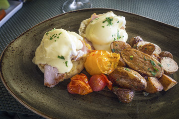 Delicious Benedict Eggs served with baked patatoes and tomatoes