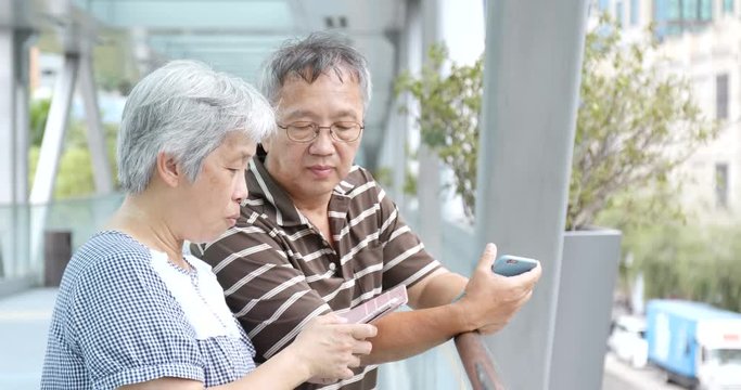 Retired couple using mobile phone at outdoor