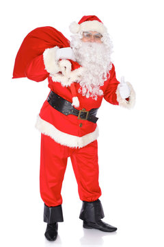 Santa Claus carrying big bag and showing thumbs up or ok isolated on white background. Full length portrait