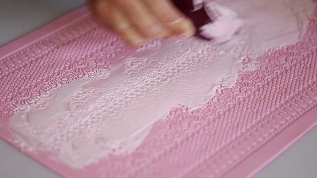 Applying cream to create lace on cake. Aising mat.